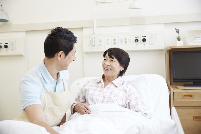 介護業界　転職-ベッドにいる患者に寄り添う男性介護士